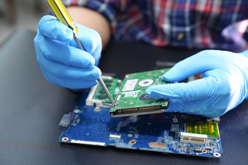 Asian Technician repairing micro circuit main board computer electronic technology : hardware,...