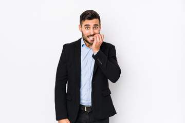 Young caucasian business man against a white background isolated biting fingernails, nervous and very anxious.