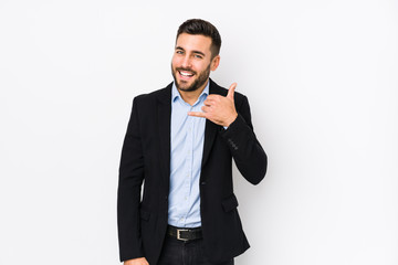 Young caucasian business man against a white background isolated showing a mobile phone call gesture with fingers.