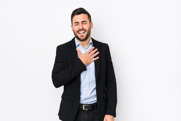 Young caucasian business man against a white background isolated laughs out loudly keeping hand on chest.