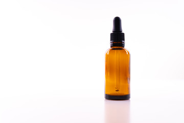 A small bottle with a dropper full of CBD oil or any other oil on white background