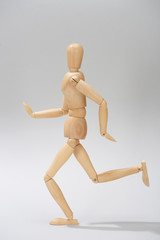 Wooden puppet with shadow on grey background