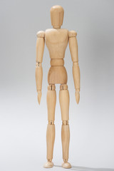 Wooden doll with hinges on grey background