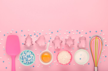 ingredients for baking and kitchen tools with cookie cutter on pink background, flat lay