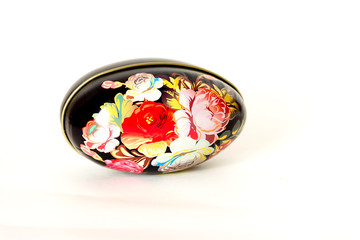 an egg-shaped box painted under khokhloma on a white background