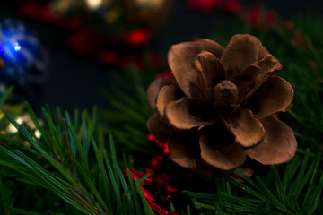 A cone on a Christmas tree with a red Christmas tree toy and other Christmas decorations on a concrete background