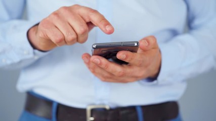 Formally dressed man using smartphone for serfing on internet close-up