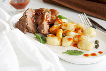 Roast venison with gnocchi on white plate