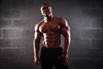 Fototapeta na wymiar African american male athlete posing demonstrating muscular development