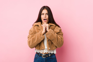 Young cute woman praying for luck, amazed and opening mouth looking to front.