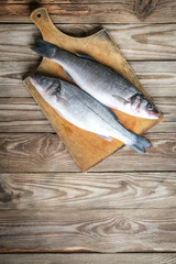 Fresh seabass . Raw fish seabass on wooden rustic table. Top view with copy space..