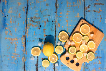Sliced Lemons and Limes with ice cube. Over blue wood table background with copy space ,spring time concept