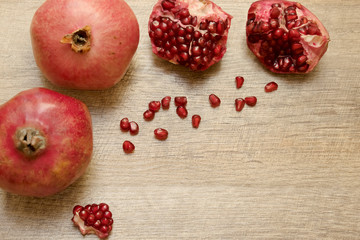 Fototapeta na wymiar Pomegranates and seeds on wooden table. Rustic background. Top view.