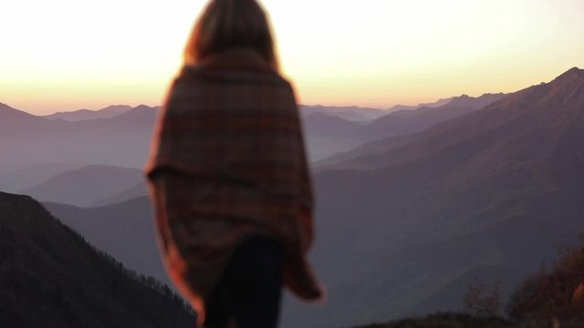 Back view of silhouette young attractive girl woman in plaid walk into cadre and enjoy the view outdoors of mountain landscape. focus on background