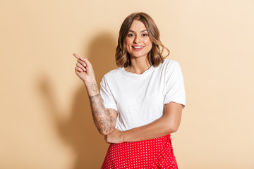 Image of pretty woman smiling and pointing finger at copyspace
