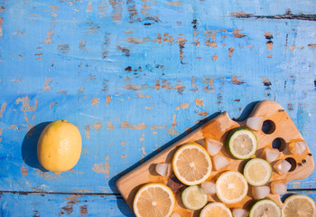 Sliced Lemons and Limes with ice cube. Over blue wood table background with copy space ,spring time concept
