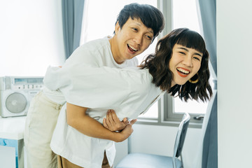 Fototapeta premium Happy young asian couple playing with happy together in room.