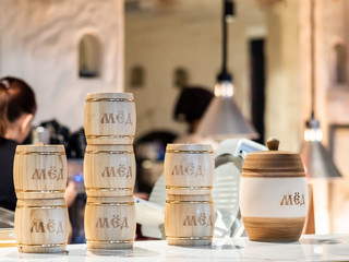Wooden barrels with the inscription honey stand on a counter in a restaurant.