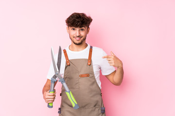 Young arab gardener man isolated person pointing by hand to a shirt copy space, proud and confident