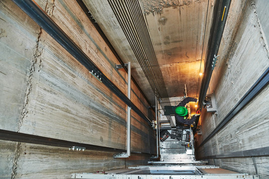 lift machinist repairing elevator in lift shaft