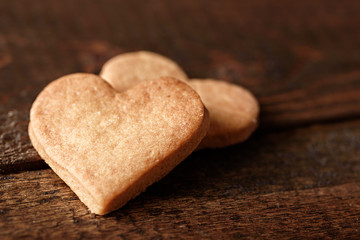 homemade cookies in the shape of heart on brown wooden background