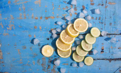 Sliced Lemons and Limes with ice cube. Over blue wood table background with copy space ,spring time concept