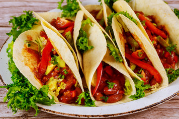 Colorful tortillas with beans, beef and vegetable with salsa.