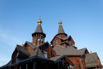 Fototapeta na wymiar Against the blue sky, a wooden church, built in the old style.