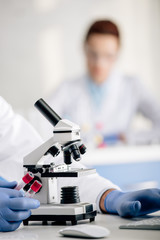 cropped view of genetic consultant holding test tubes in lab