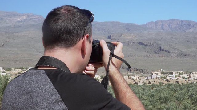 Caucasian Male Tourist Taking Photos of Abandoned Old Ruined Village of Al Hamra near Nizwa, Oman
