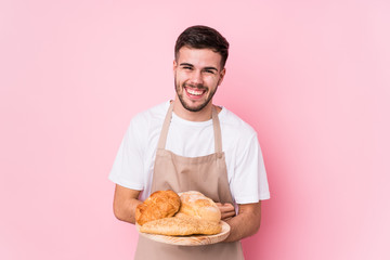 Young caucasian baker man isolated laughing and having fun.