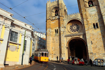 Plakat The iconic 28 tram in front of the Cathedral of St. Mary Major, simply called the Sé, into historic Alfama district, Lisbon, Portugal