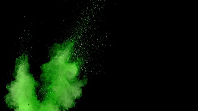 Realistic green powder dust explosion on black background. Slow motion movement from left of screen