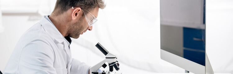 panoramic shot of molecular nutritionist using microscope in lab