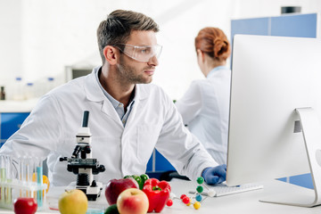 molecular nutritionist in white coat using computer in lab