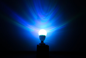 Beautiful night lamp standing on the floor. Blue shadows on the walls.