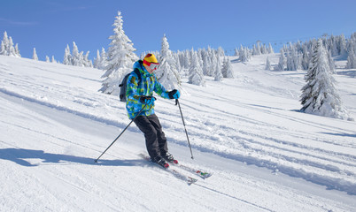 Fototapeta na wymiar Active Skier skiing downhill on ski piste in mountains 