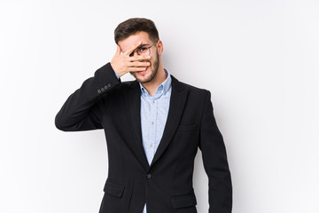 Young caucasian business man posing in a white background isolated Young caucasian business man blink at the camera through fingers, embarrassed covering face.