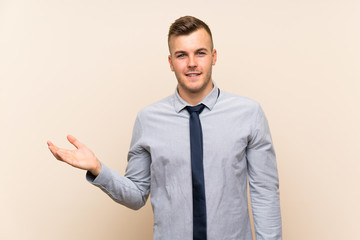 Young blonde businessman over isolated background holding copyspace imaginary on the palm