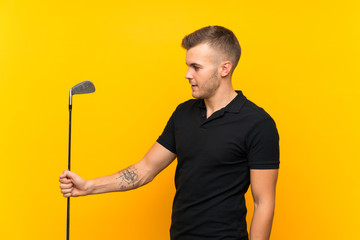 Golfer player man over isolated yellow background with happy expression