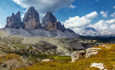 Great sunny view of the National Park Tre Cime di Lavaredo, Panoramic view of three spectacular mountain peaks. Awecome nature landscape. Amazing mountain valley under sunlight. Dolomites Alps.