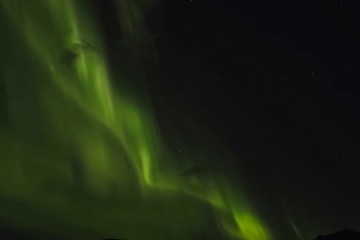 Aurora borealis in night northern sky. Ionization of air particl