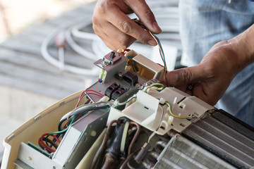 The technician is repairing the air conditioner.