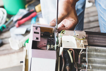 The technician is repairing the air conditioner.