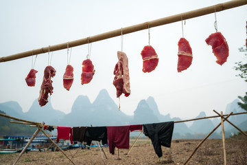The dried meat and clothes hung in the fishing village in Yangshuo, China