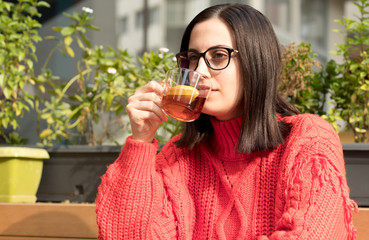 Beautiful young woman with a cup of tea at a cafe