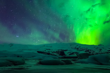 Fototapeta na wymiar Aurora borealis in night northern sky. Ionization of air particl