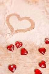 Fototapeta premium The concept of baking for Valentine's Day with torches in the shape of a heart . the heart is drawn on the flour in the process of making cookies