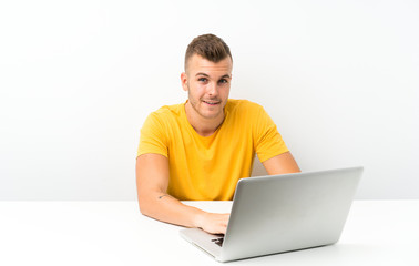 Young blonde man in a table with a laptop