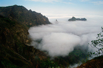 Valley between mountains covered with clouds